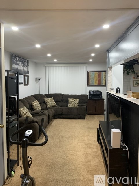 A living room with a dark brown couch and a television.