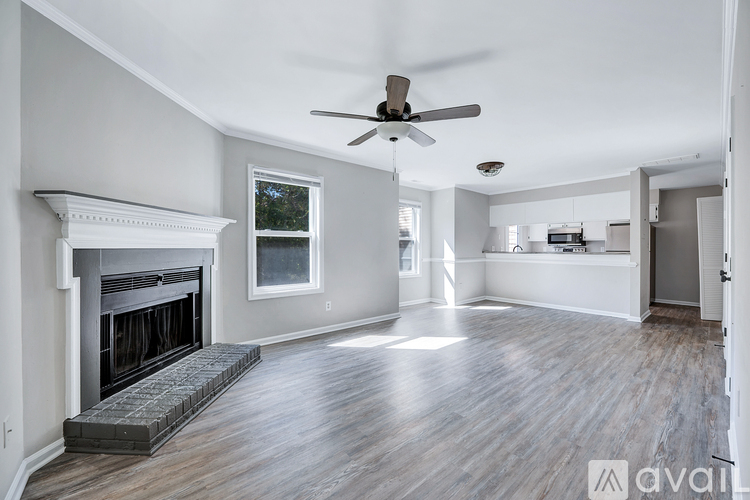 A spacious living room with a fireplace and hardwood floors.