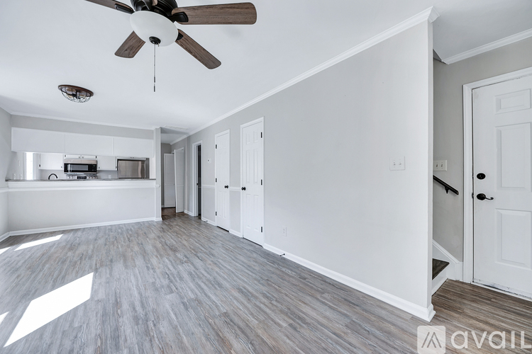 A room with a ceiling fan and wooden flooring.