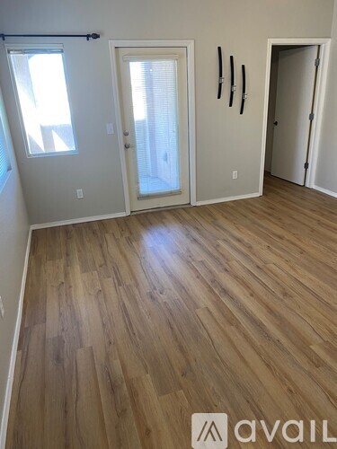 A room with wooden flooring and three doors.