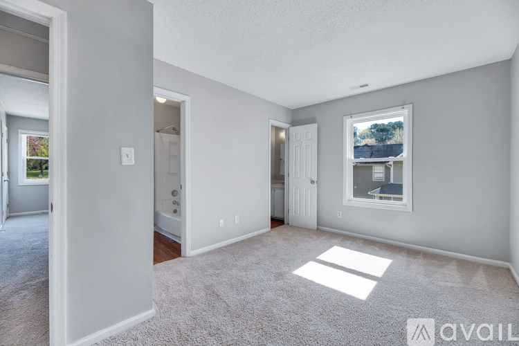 A spacious living room with a carpeted floor and a large window.