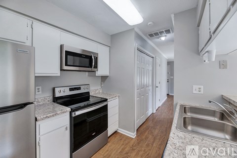 A kitchen with white cabinets and stainless steel appliances.