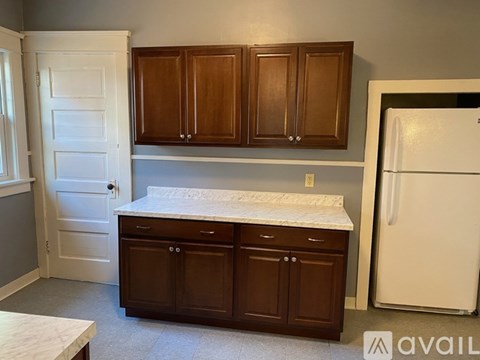 A kitchen with brown cabinets and a white fridge.