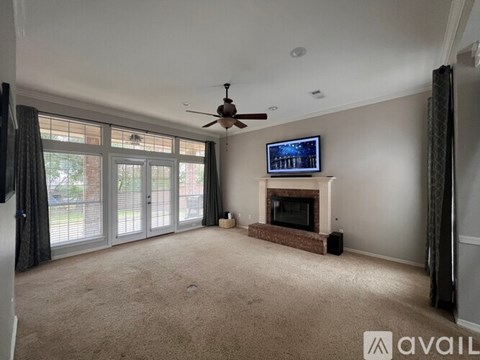 A living room with a fireplace and a television on the wall.