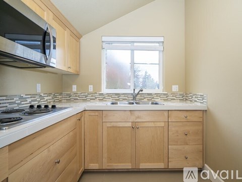 A kitchen with wooden cabinets and a stone backsplash.