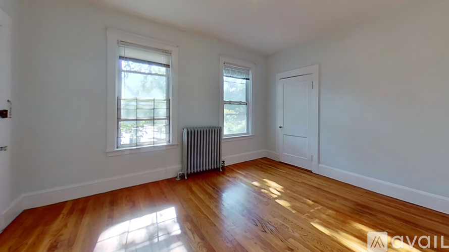 A room with wooden floors and two windows.