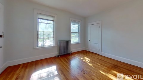 A room with wooden floors and two windows.