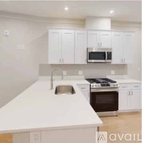 A modern kitchen with white cabinets and appliances.
