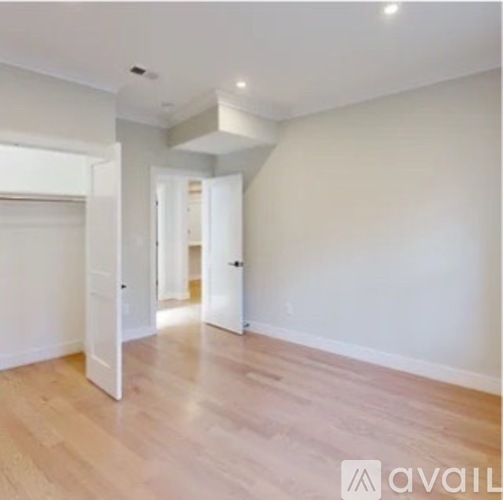 A room with wooden flooring and white walls.
