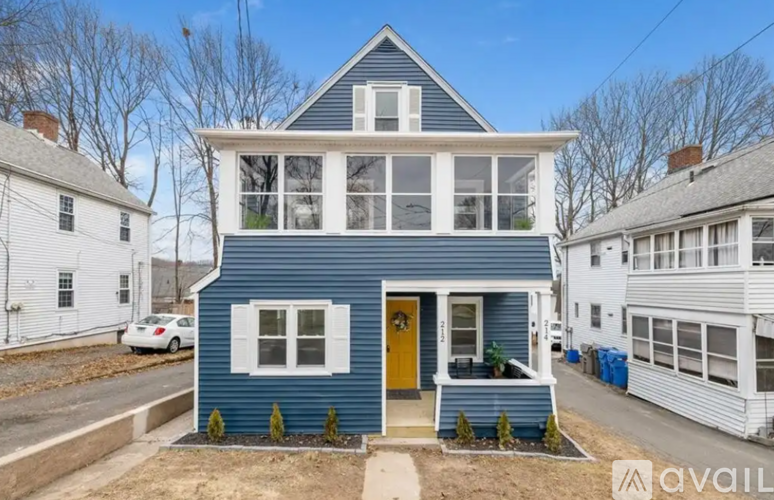 A blue house with a yellow door is for sale.
