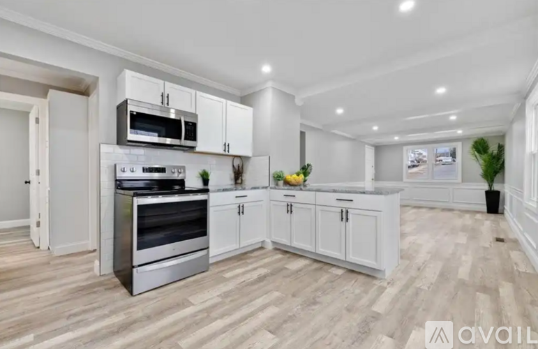 A modern kitchen with a stainless steel oven and white cabinets.