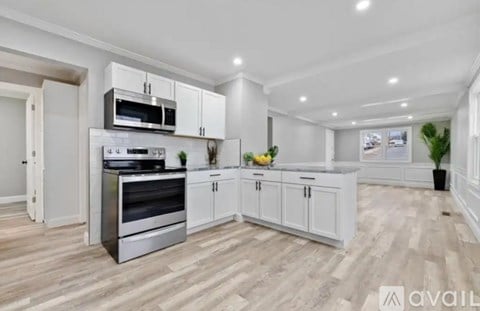 A modern kitchen with a stainless steel oven and white cabinets.