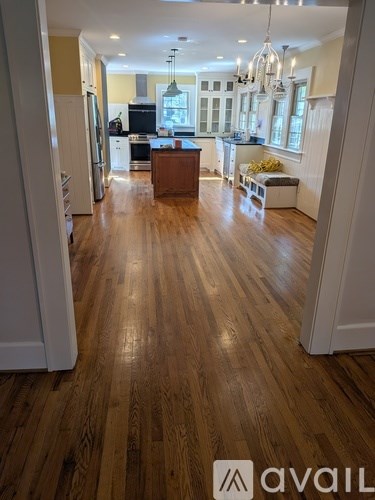 A kitchen with a wooden floor and white cabinets.