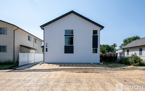 A white house with a black roof and a small porch.