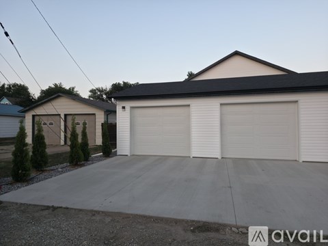 A two-car garage with a white exterior and a black roof is available for rent.