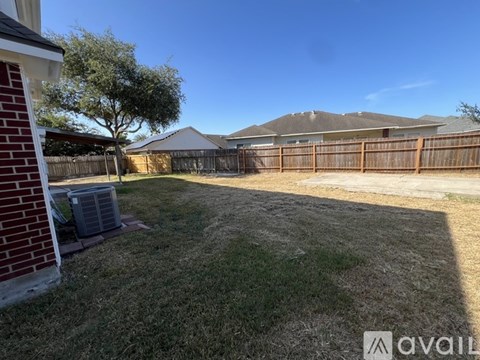 A backyard with a fence and a tree.