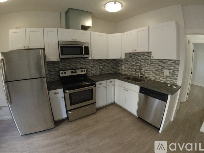 A kitchen with stainless steel appliances and white cabinets.