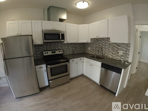 A kitchen with stainless steel appliances and white cabinets.