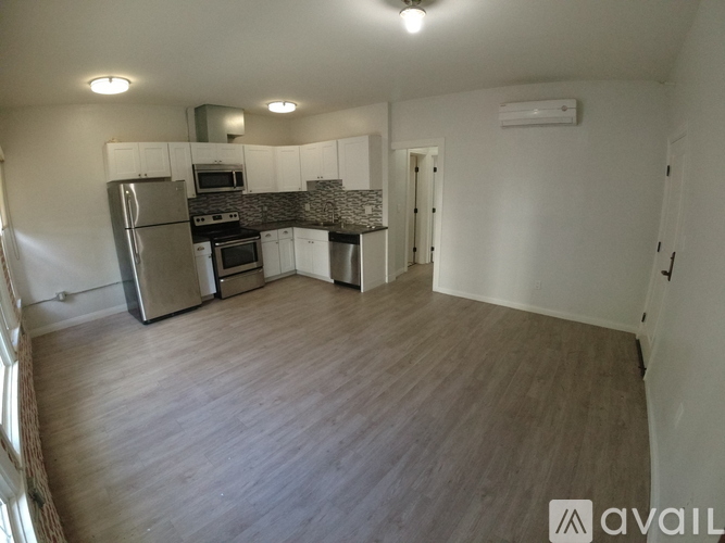 A kitchen with a refrigerator, microwave, and oven.