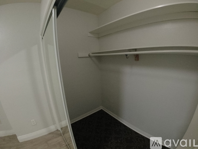 A small, empty room with a single shelf and a door.