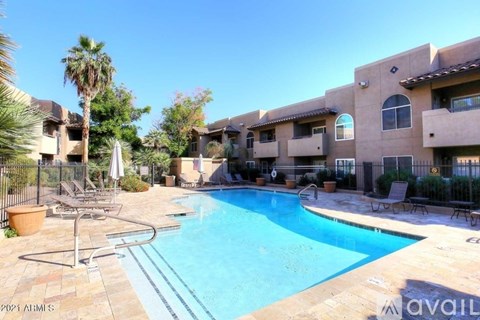A pool surrounded by a patio with chairs and a fence.