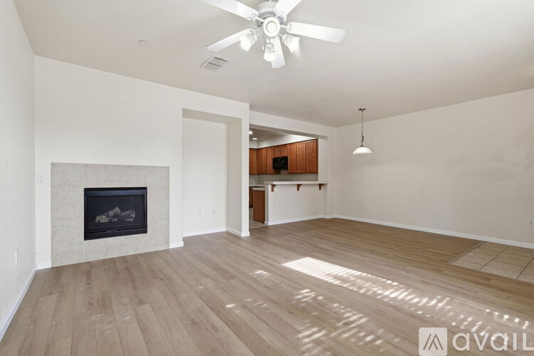 A spacious room with a fireplace and wooden flooring.