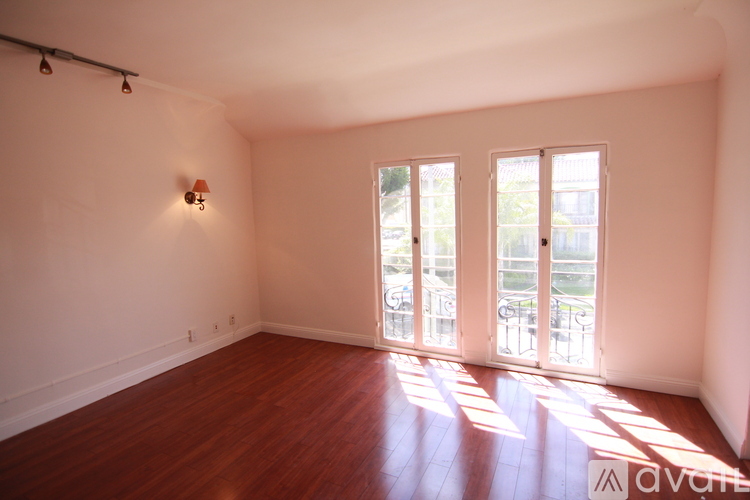 A room with wooden floors and a wall-mounted light fixture.