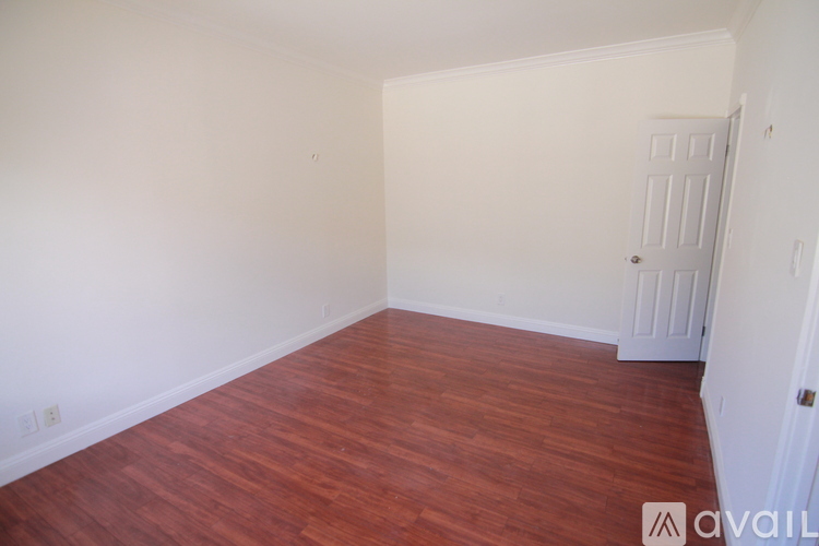A room with wooden flooring and a white door.