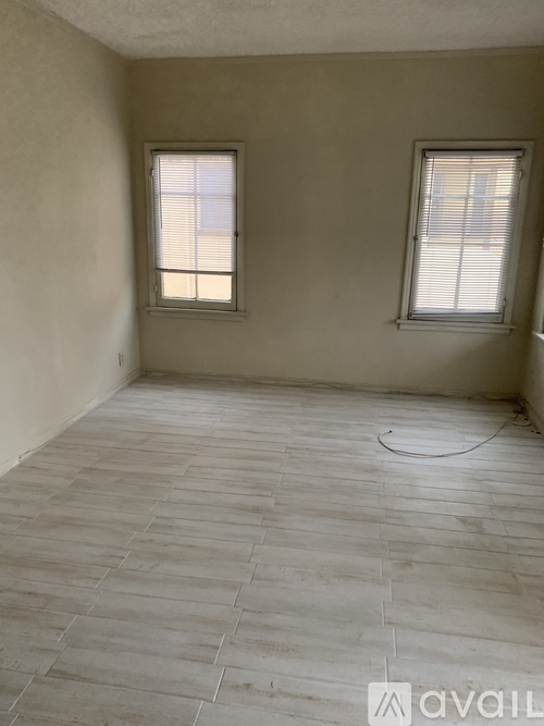 A room with two windows and tile flooring.