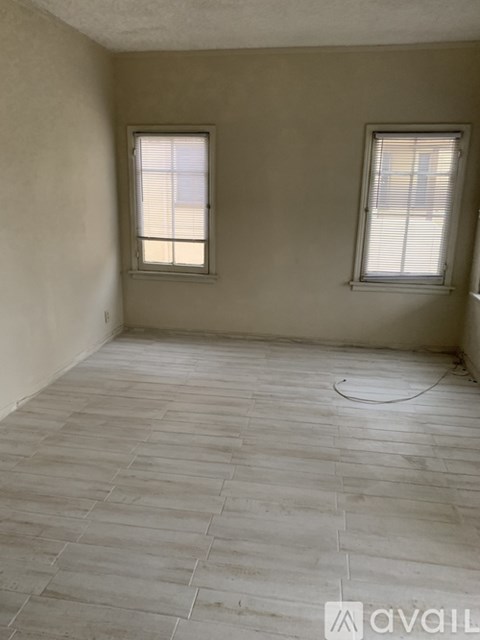 A room with two windows and tile flooring.