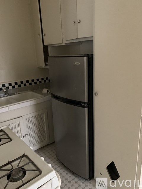 A kitchen with a stove top oven and a refrigerator.