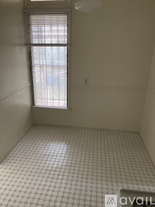 A bathroom with a tiled floor and a window.
