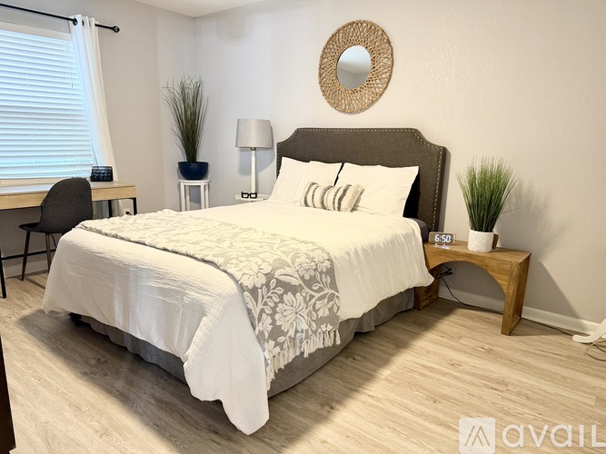 A bedroom with a large bed and a mirror on the wall.