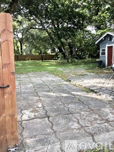 A backyard with a concrete walkway and a wooden fence.