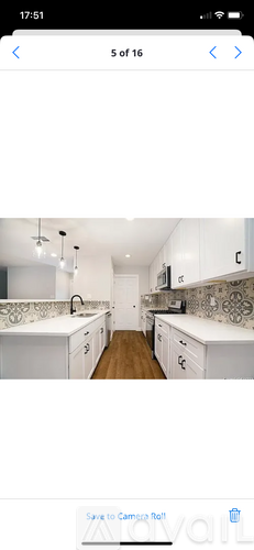 A kitchen with white cabinets and a wooden floor.