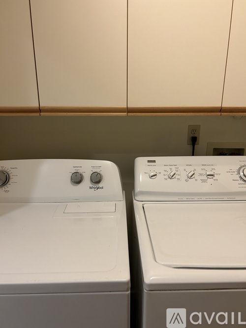 Two Whirlpool washing machines are stacked on top of each other.