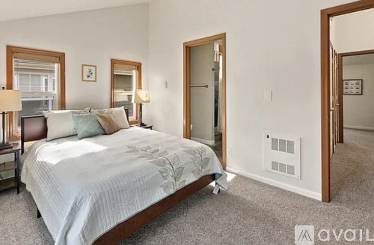 A bedroom with a large bed and a mirror on the wall.