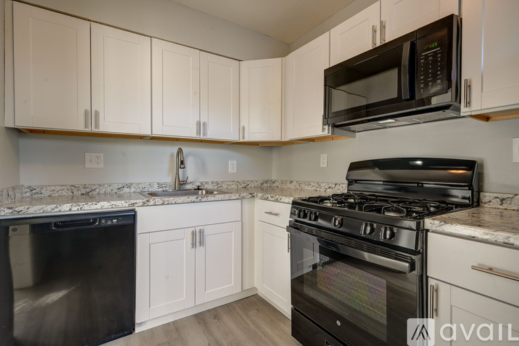A kitchen with a black stove and white cabinets.