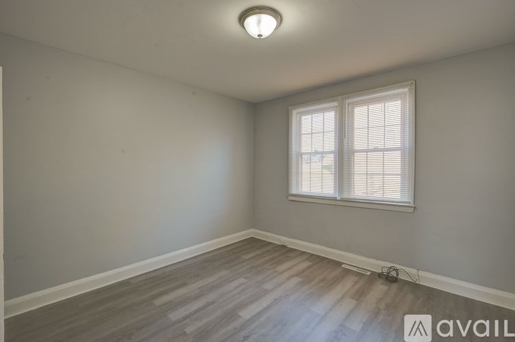 A room with a window and wooden flooring.