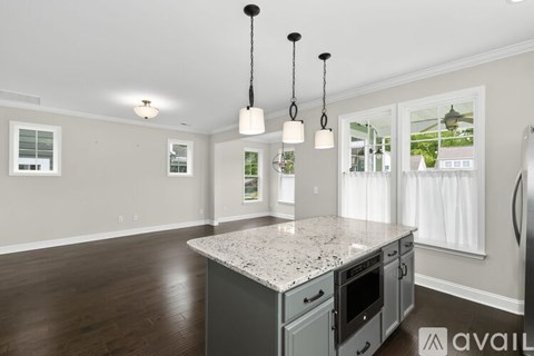A kitchen with a granite countertop and a refrigerator.