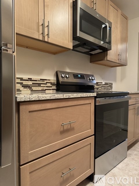A kitchen with wooden cabinets and a black oven.