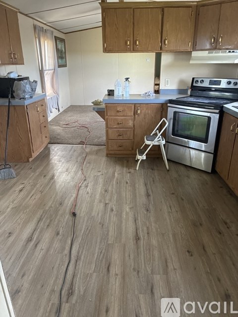 A kitchen with wooden floors and a stove top oven.