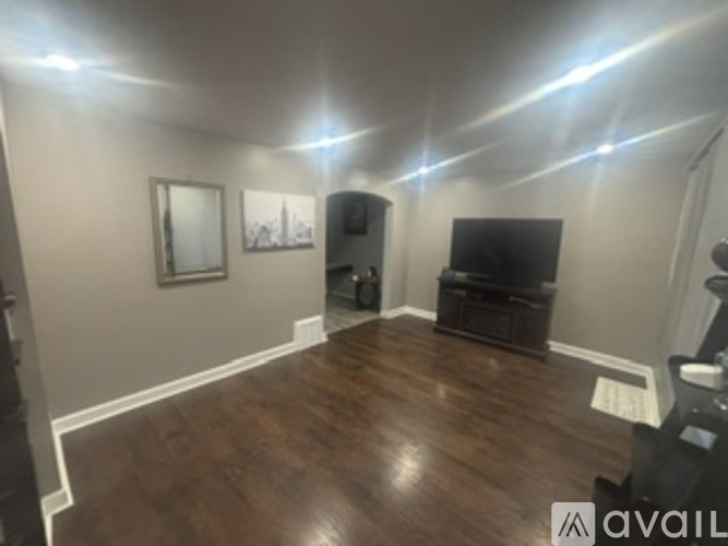 A living room with wood floors and a flat screen TV.