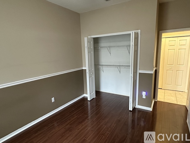 A room with a white door and a white fridge.