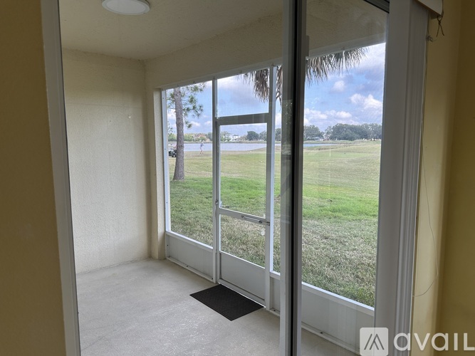 A room with a view of a grassy field through a sliding glass door.