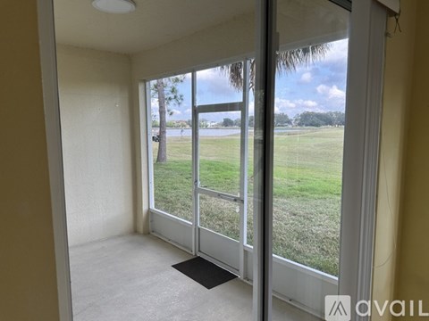 A room with a view of a grassy field through a sliding glass door.
