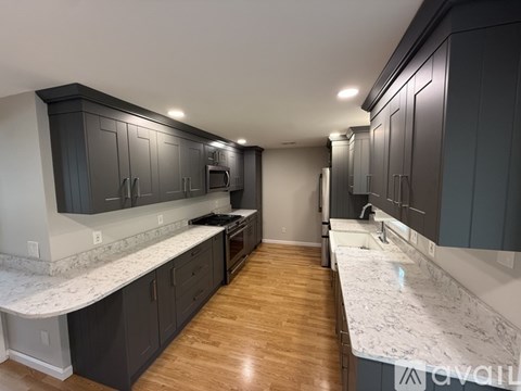 A kitchen with dark cabinets and a marble countertop.