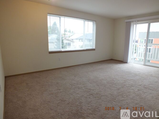 A room with a carpeted floor and two windows, one of which is open.