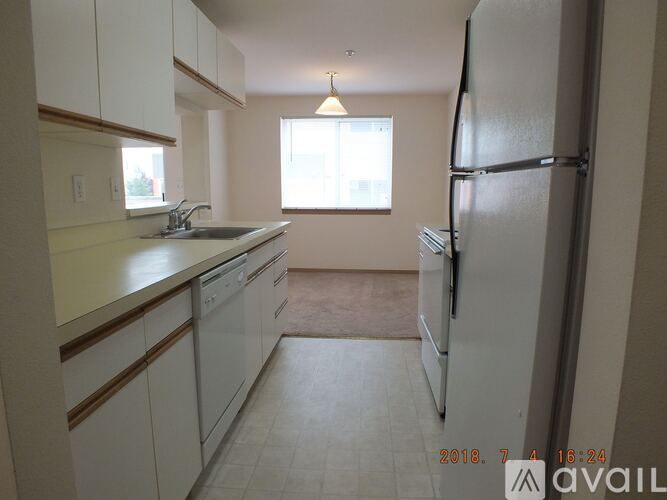 A kitchen with white cabinets and a refrigerator.