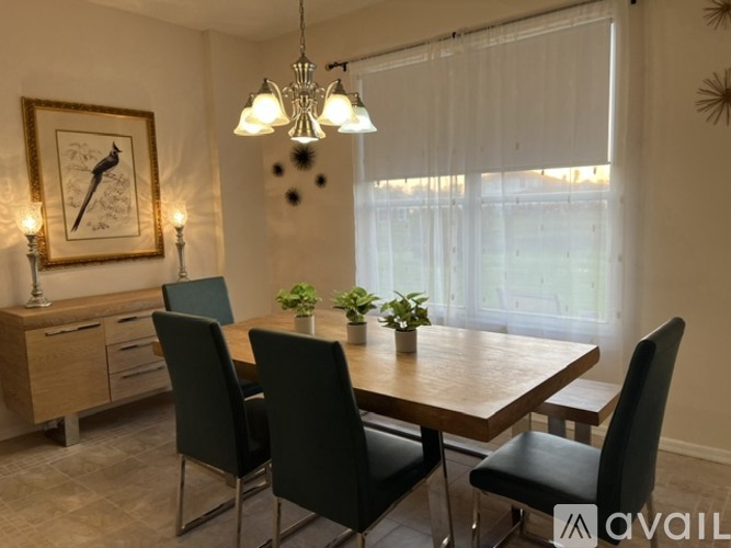 A dining room with a wooden table and chairs.